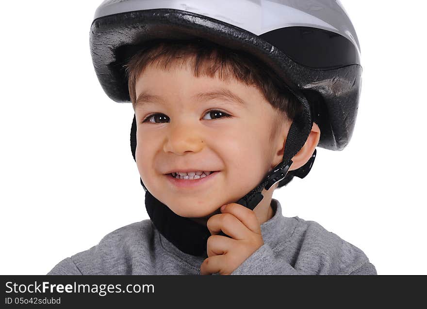 Little cheerful boy buckles his helmet up. He wears grey sports clothes isolated on white background. Little cheerful boy buckles his helmet up. He wears grey sports clothes isolated on white background.