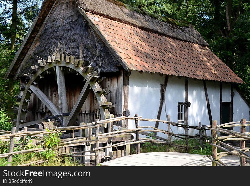 Countryside with watermill and old house.