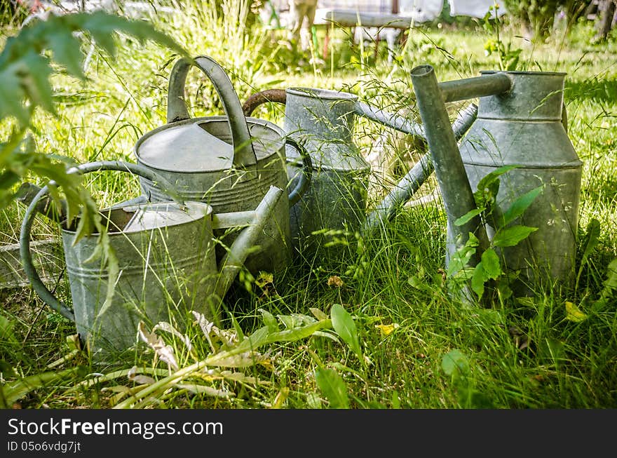 Old and rusty watering cans in a garden