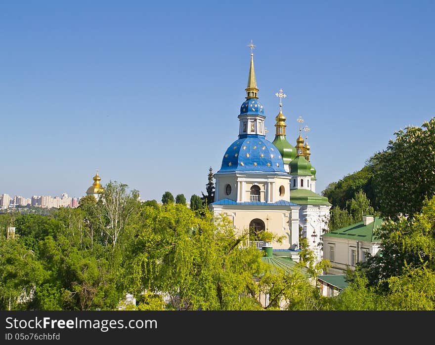 View of Vydubychi monastery buildings in green trees in spring. View of Vydubychi monastery buildings in green trees in spring