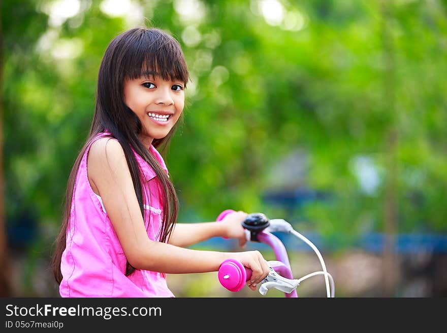 Little asian girl in a bicycle