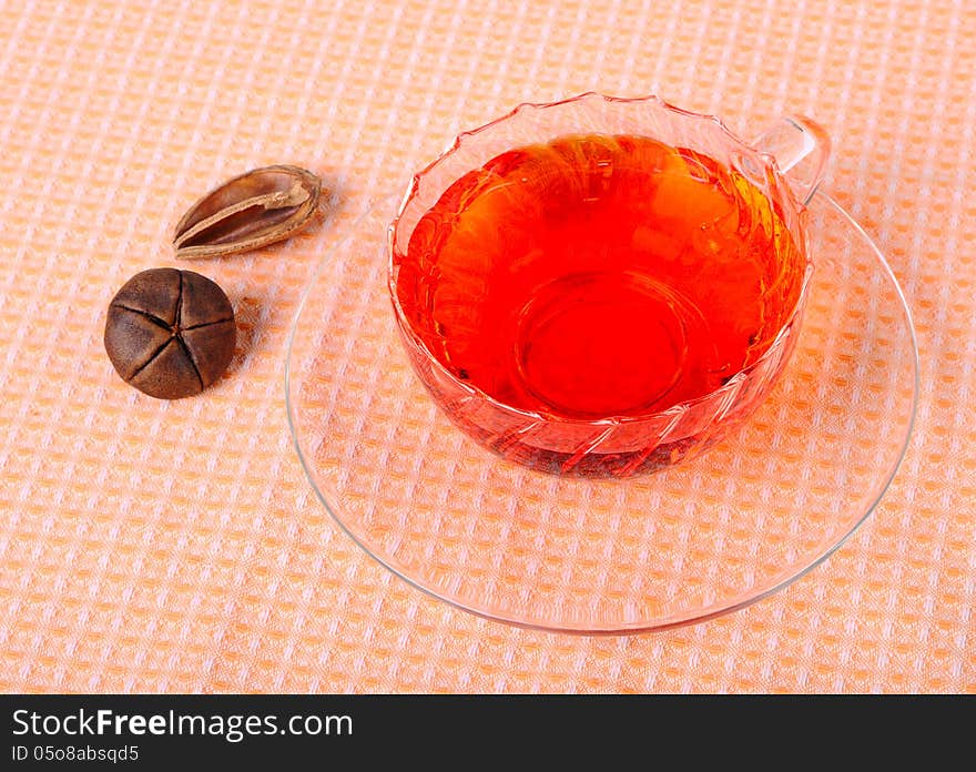 Tea in a glass cup, a glass saucer and decoration. Tea in a glass cup, a glass saucer and decoration