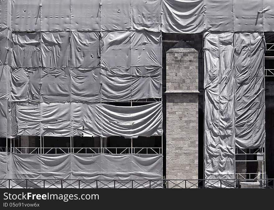 Building under construction covered with wrinkled tarpaulin canvas. Building under construction covered with wrinkled tarpaulin canvas