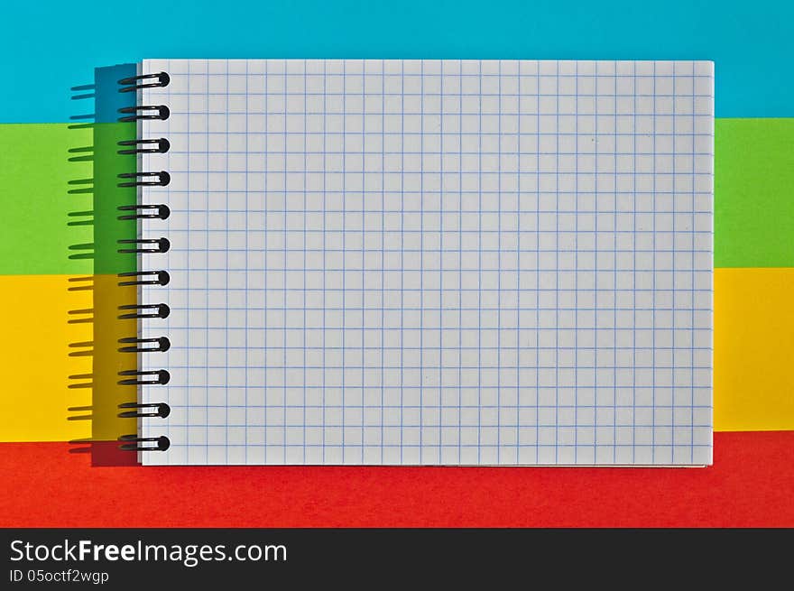 Open note book with space for writing lies on a colorful background