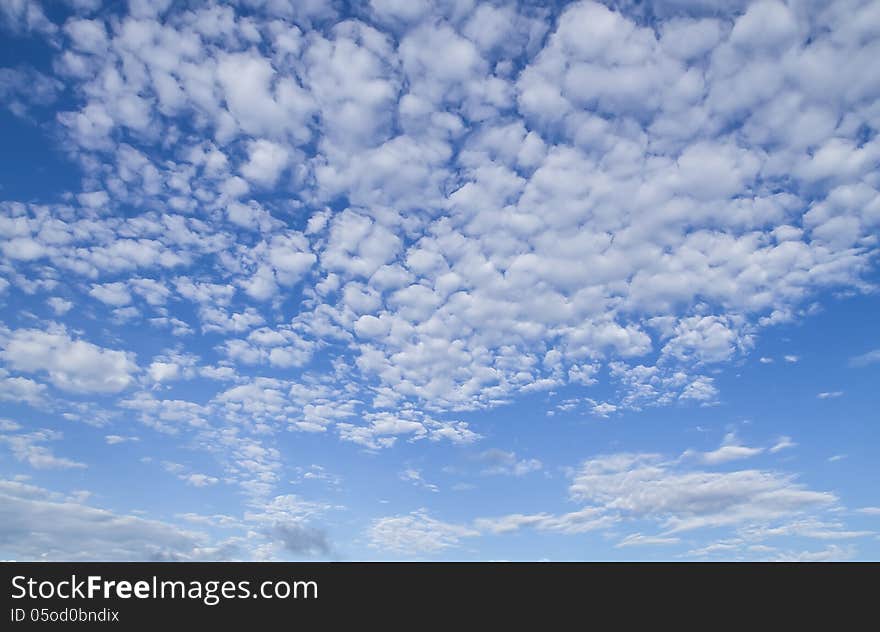 White sparse clouds over blue sky.