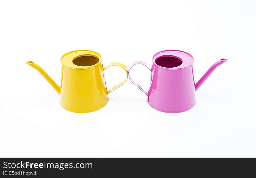 Pink and yellow water cans on white background.