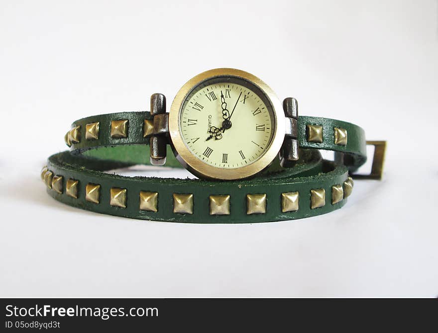 Quartz woman wrist watch with green leather strap on white background.