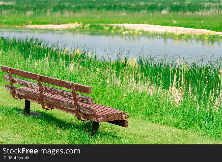 View of lake and empty old wooden bench. View of lake and empty old wooden bench