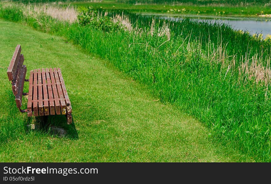 View of lake and empty old wooden bench. View of lake and empty old wooden bench