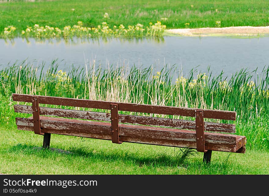 View of lake and empty old wooden bench. View of lake and empty old wooden bench