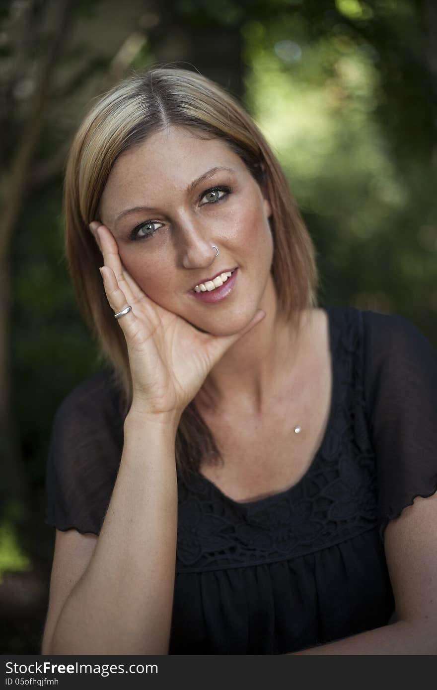 Portrait of a blonde woman with blue eyes with her hand on her face. Portrait of a blonde woman with blue eyes with her hand on her face.