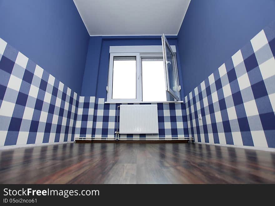 Empty room with a blue wall and blue-white wallpaper