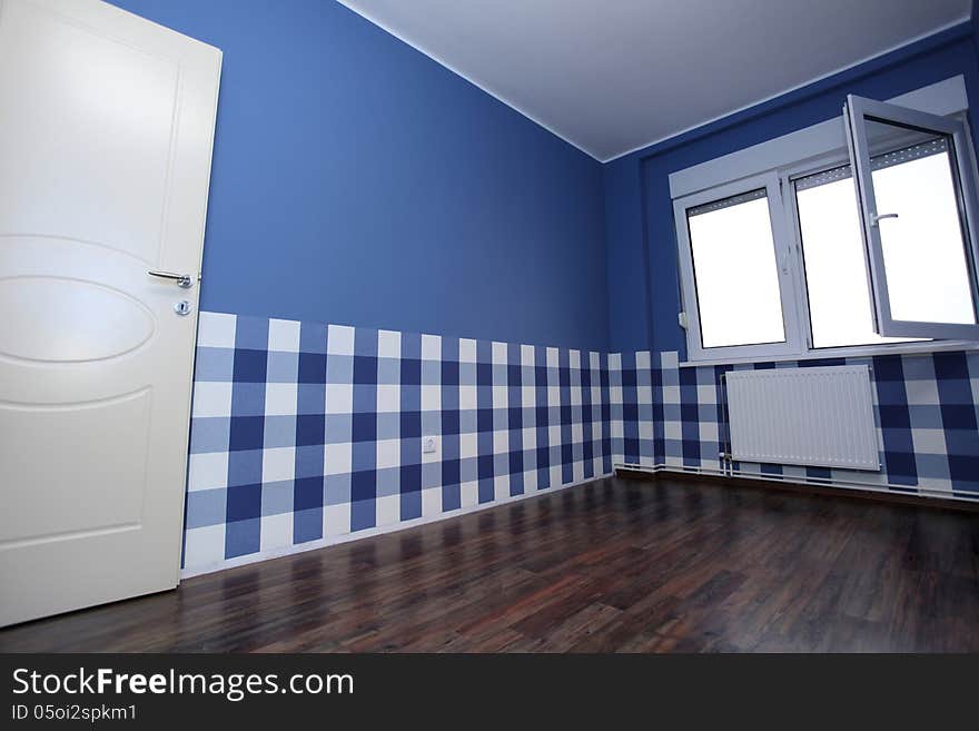 Empty room with a blue wall and blue-white wallpaper