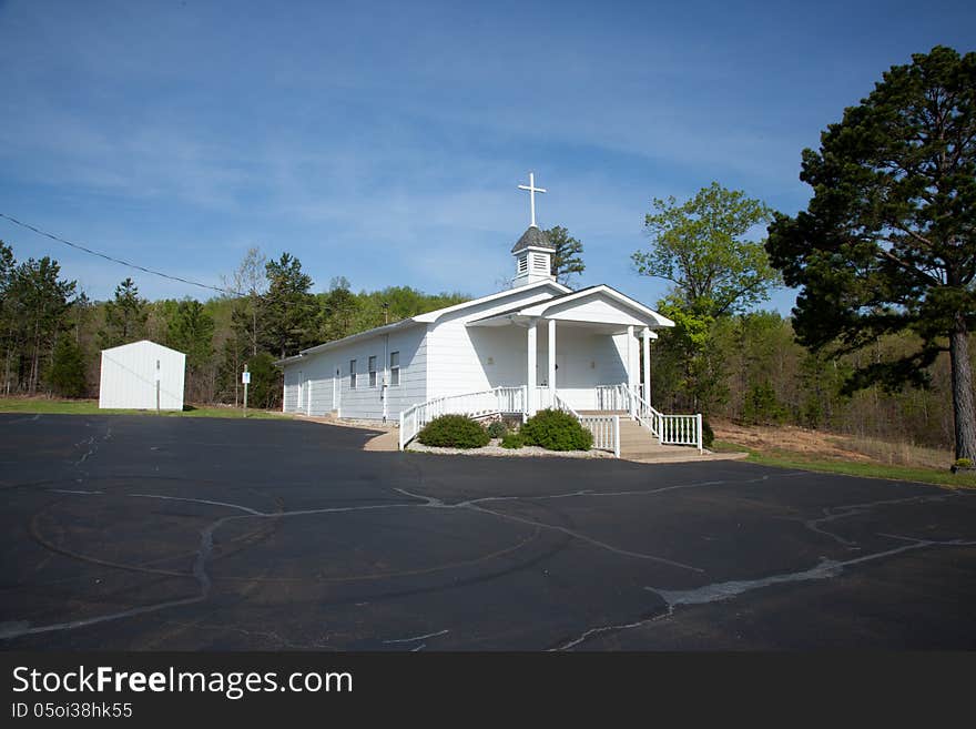 A white country church under a blue sky.