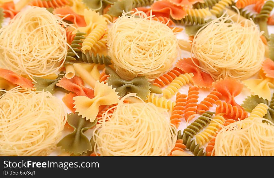 A different pasta in three colors close-up on the white background. A different pasta in three colors close-up on the white background.