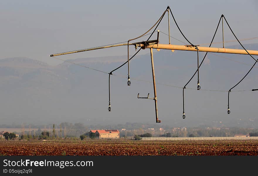 End of irrigation boom with farm buildings in background. End of irrigation boom with farm buildings in background