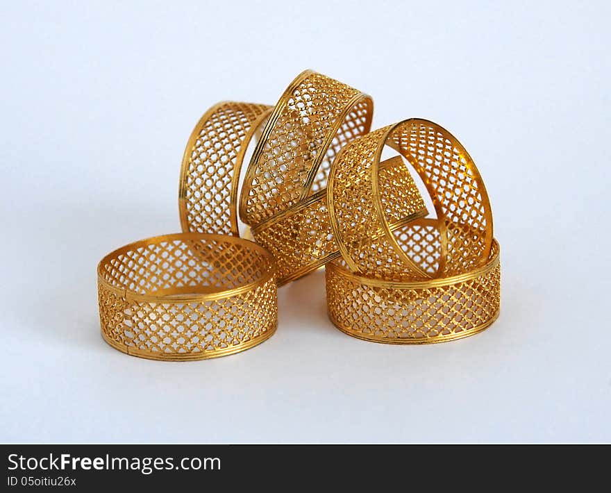 Golden napkin holders in the form of openwork rings. Golden napkin holders in the form of openwork rings