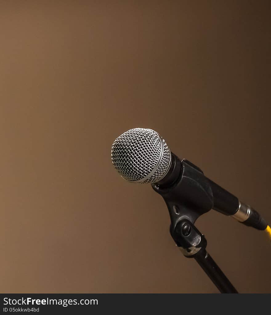 Classic black microphone on black stand. brown background. Classic black microphone on black stand. brown background