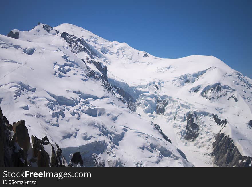 Snow peak of Mont-Blanc mountain, close, with traces of mountaineers. Chamonix, France. Taken in July 2013.