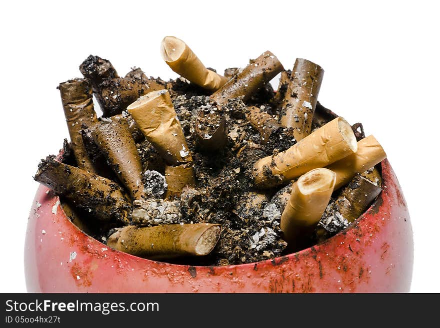 A pile of old and fresh cigarette butts in old, rusty, red ashtray. A pile of old and fresh cigarette butts in old, rusty, red ashtray.