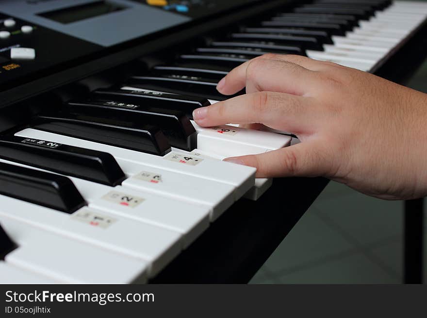 View training and playing electronic music keyboard closeup of students in the classroom.