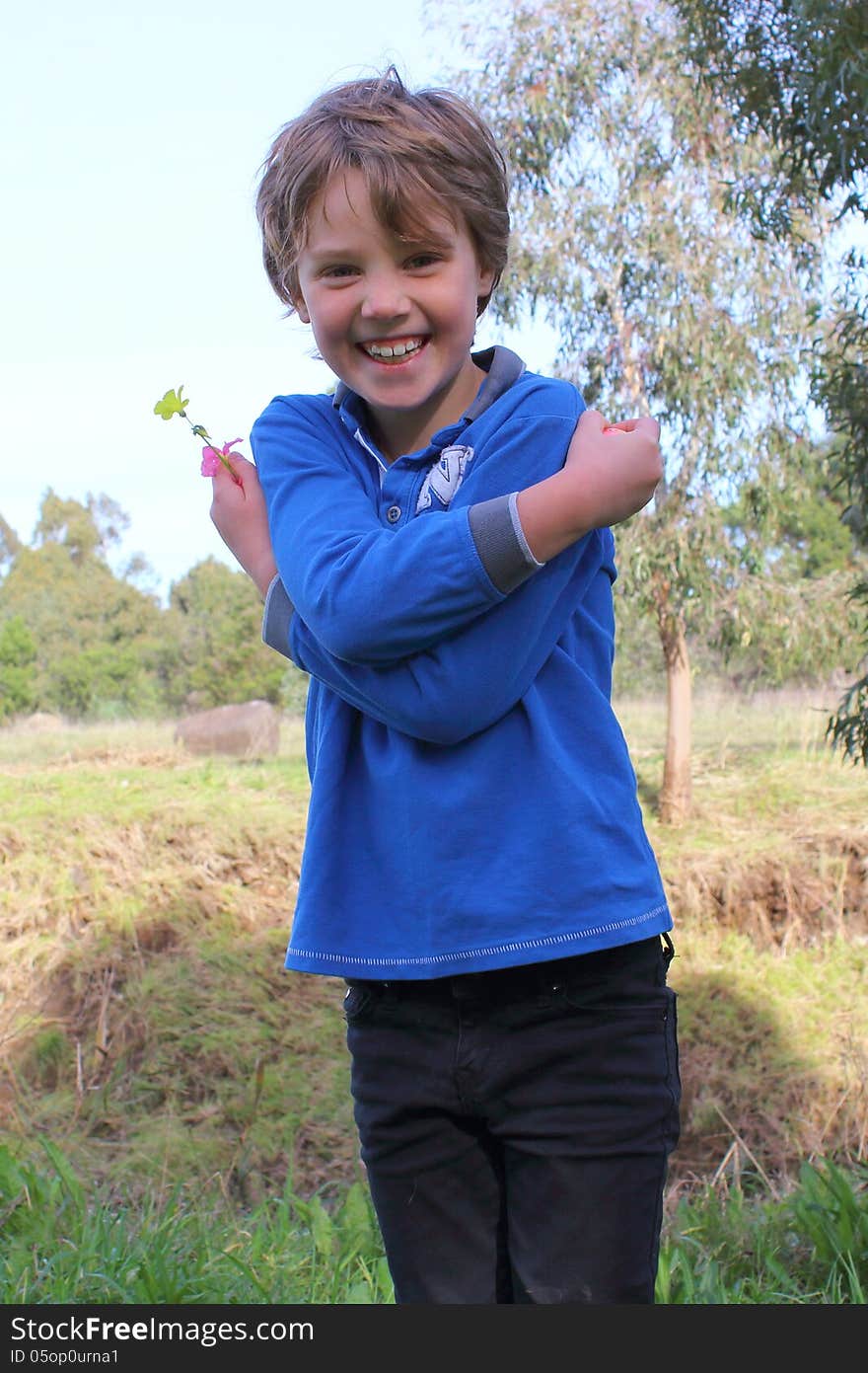 Six-year-old-girl posing and laughing while walking and collecting wild flowers in Australian parkland. Six-year-old-girl posing and laughing while walking and collecting wild flowers in Australian parkland