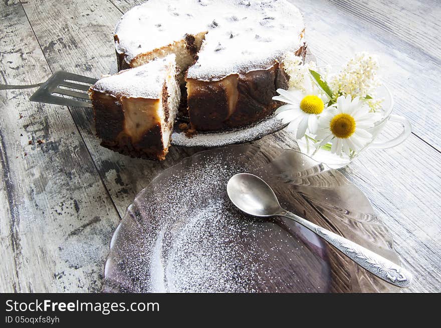 Cheesecake on a glass dish whith bouquet of chamom