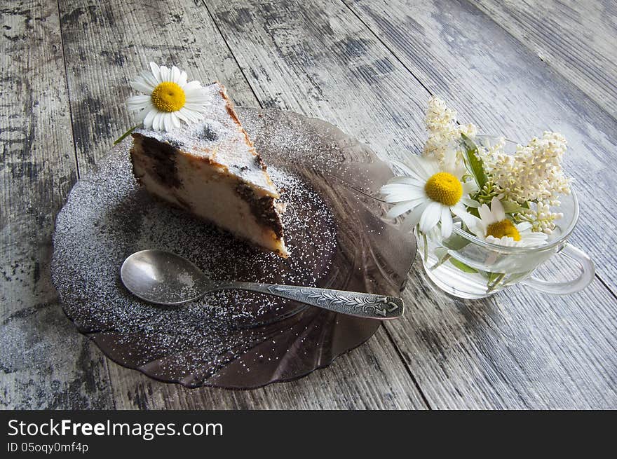 Slice of cheesecake on a glass dish with bouquet o