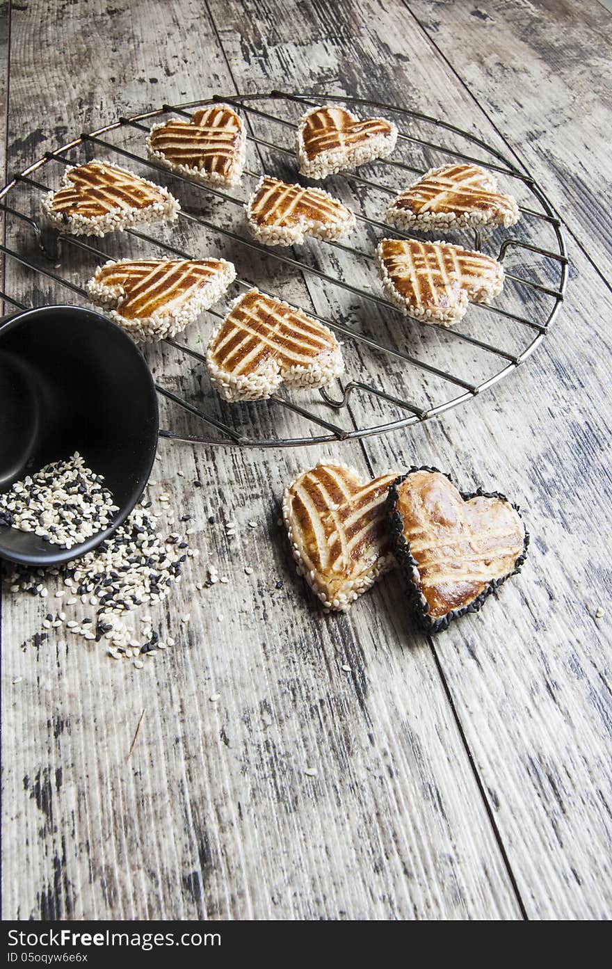 Cookies whith sesame in the shape of heart on the metal grille