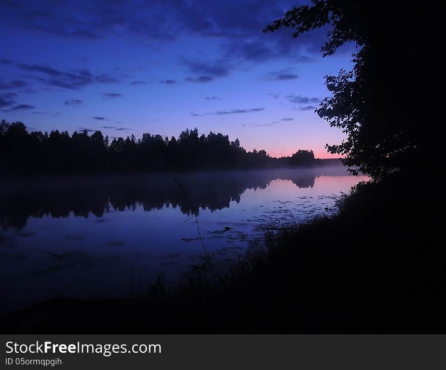 Night landscape reflection of the sky and the trees in the water