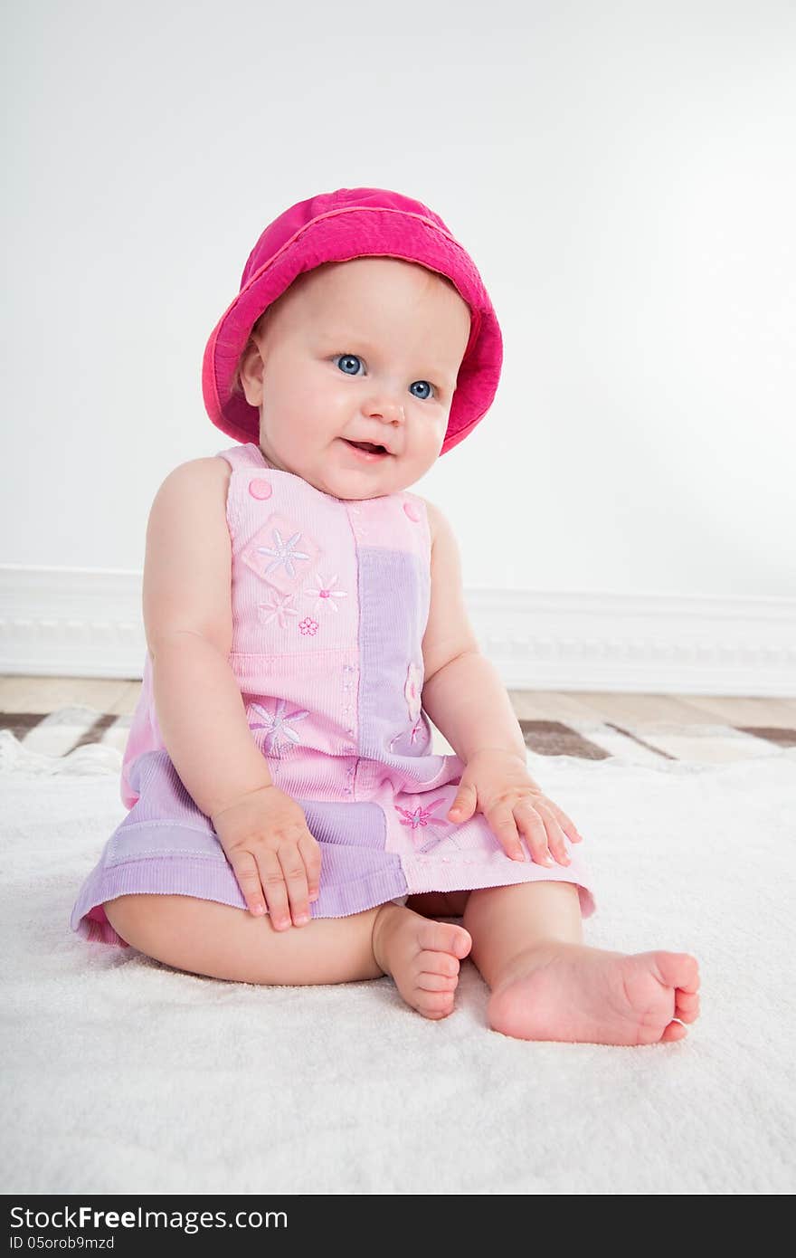 Pretty baby girl with big blue eyes sits in pink dress. Pretty baby girl with big blue eyes sits in pink dress