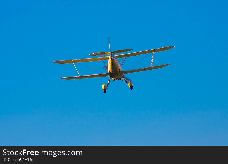 An old but well kept, yellow biplane coming in for a landing. An old but well kept, yellow biplane coming in for a landing.