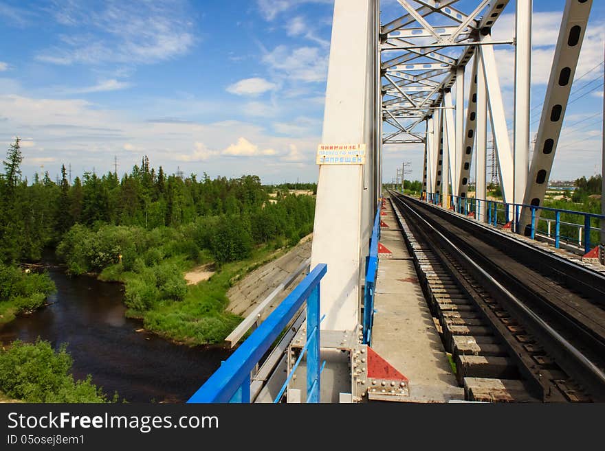 Old railway bridge blue with a blue sky with clouds