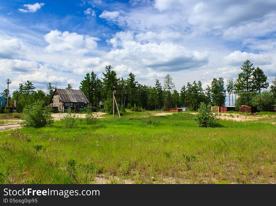 Wooden house in the north village with green meadow and blue clouds