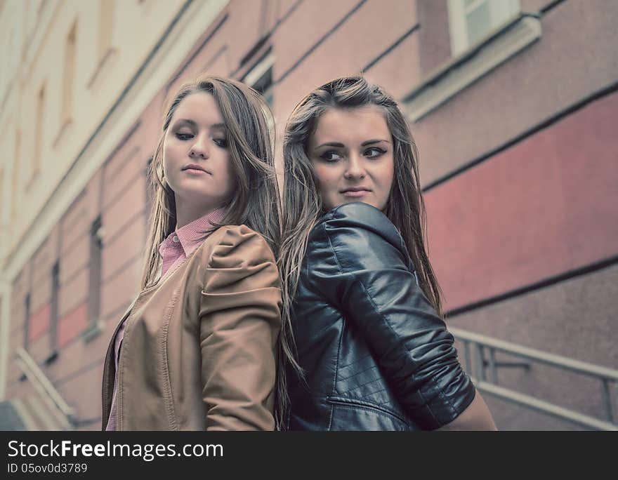 Two beautiful sisters of the girlfriend stand on street