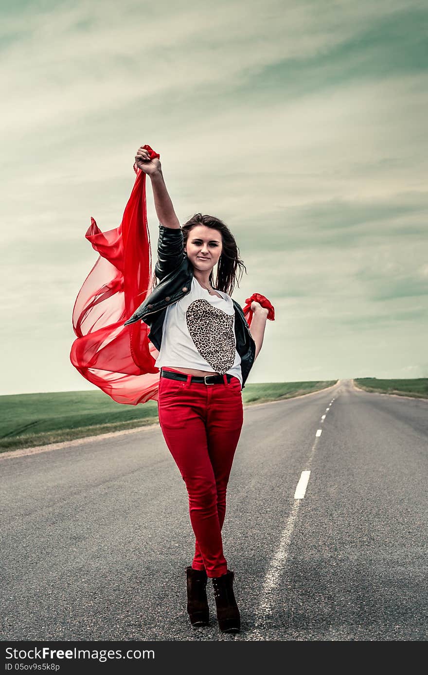 Beautiful girl stay on road with fabric opening wide from wind