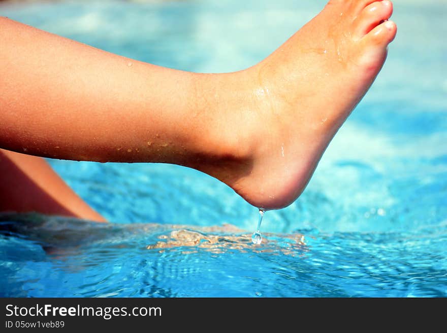 Boys playing at the pool splash with her feet