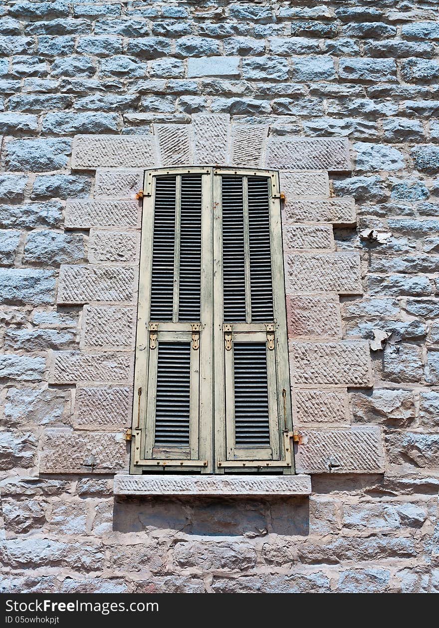 Typical old Mediterranean window with closed shutters