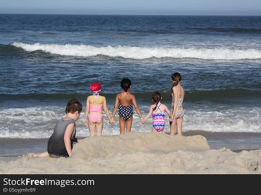 Girls holding hands at beach