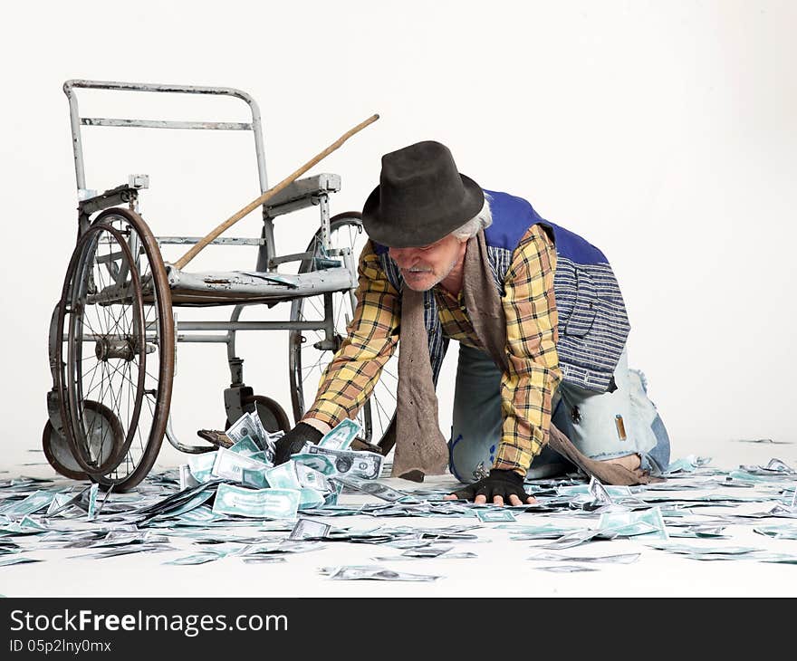 Homeless man with a wheelchair with a lot of money on a white background. Homeless man with a wheelchair with a lot of money on a white background