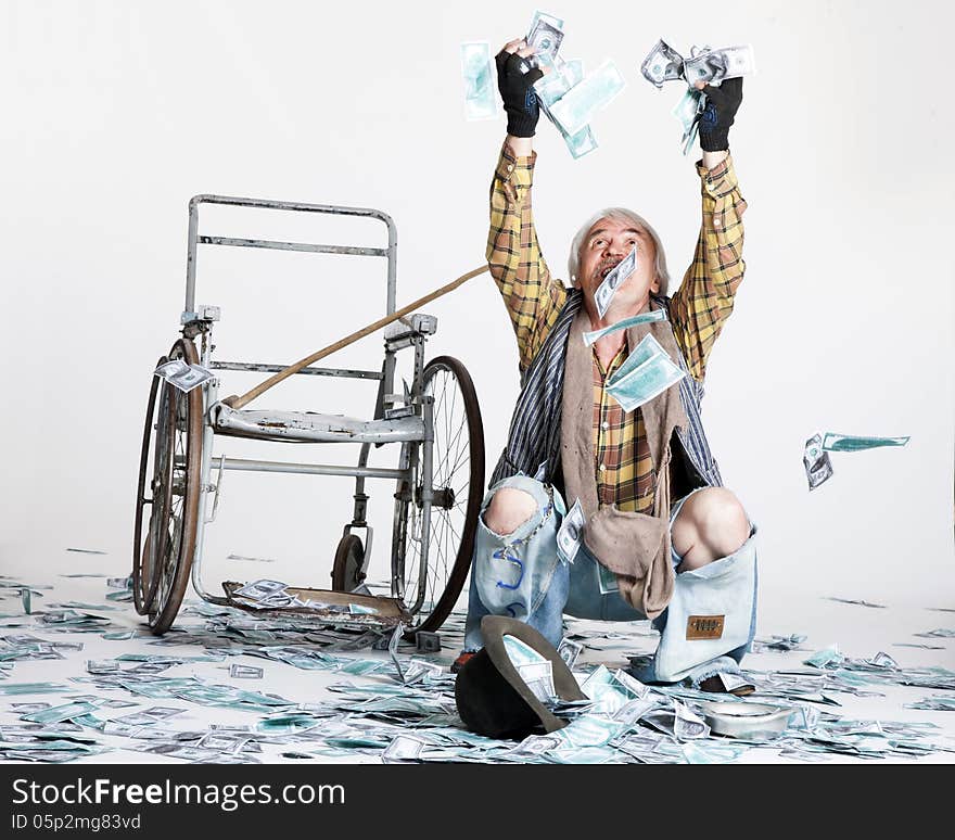 Homeless man with a wheelchair with a lot of money on a white background. Homeless man with a wheelchair with a lot of money on a white background