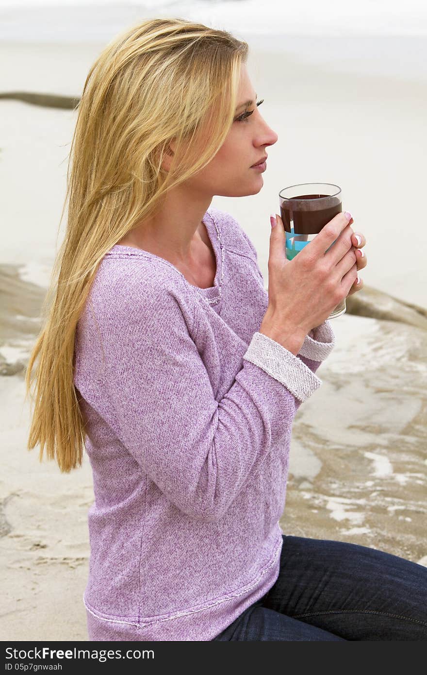 A beautiful young woman looks out over the beach in the early morning. A beautiful young woman looks out over the beach in the early morning