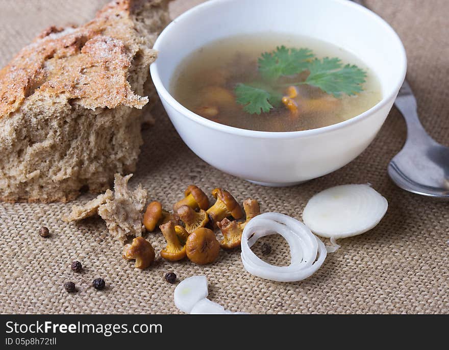 Cup of soup with chanterelles with onion and bread