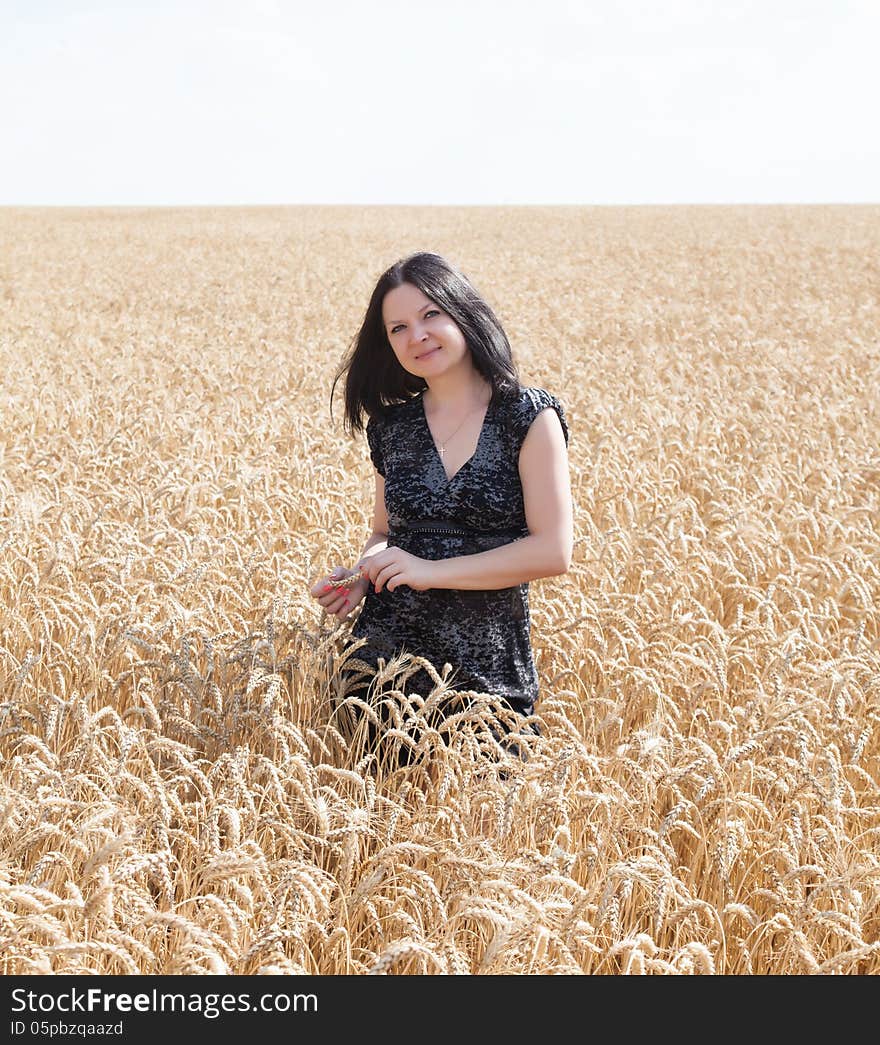 Girl on the field with wheat summer day