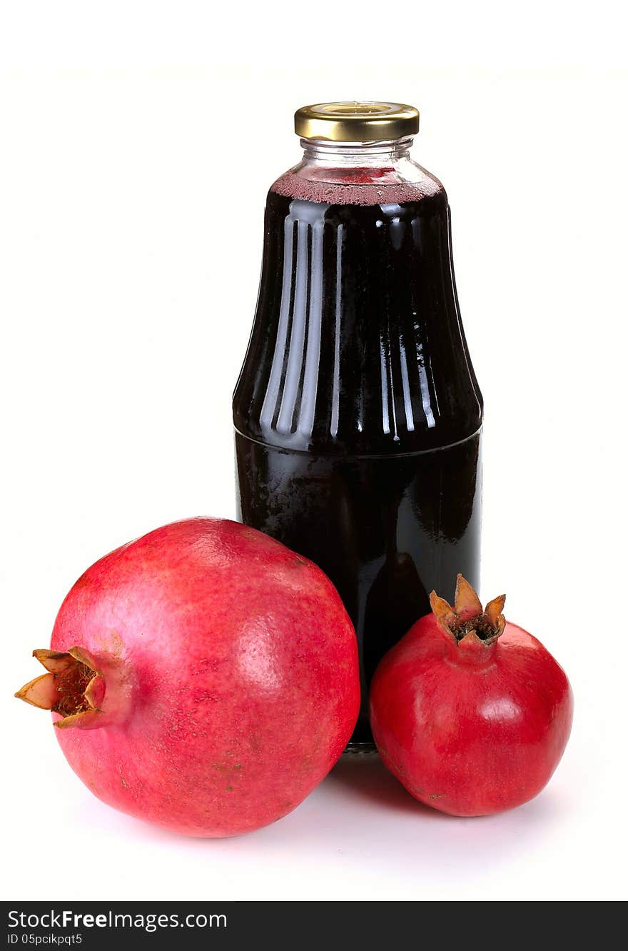 Bottle of juice and ripe pomegranate on white background