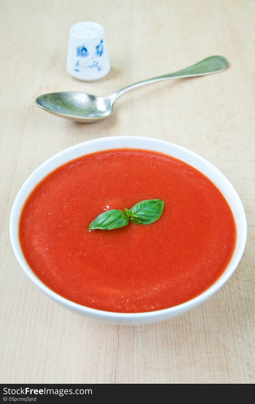 Fresh tomato soup with basil in a bowl