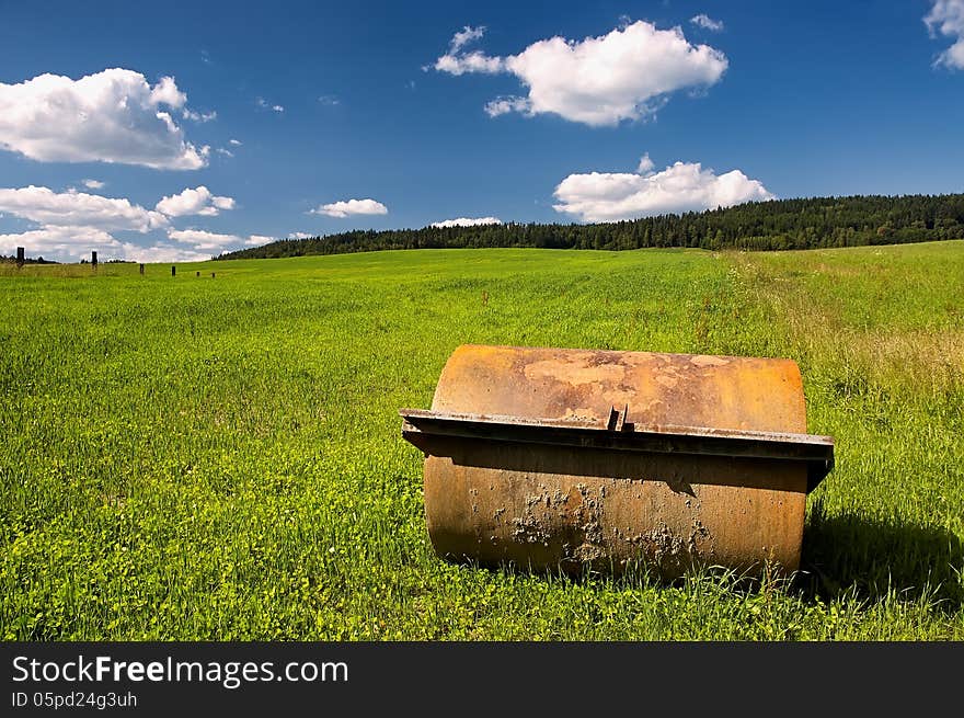 Agricultural machine on the field with trees in the background. Agricultural machine on the field with trees in the background