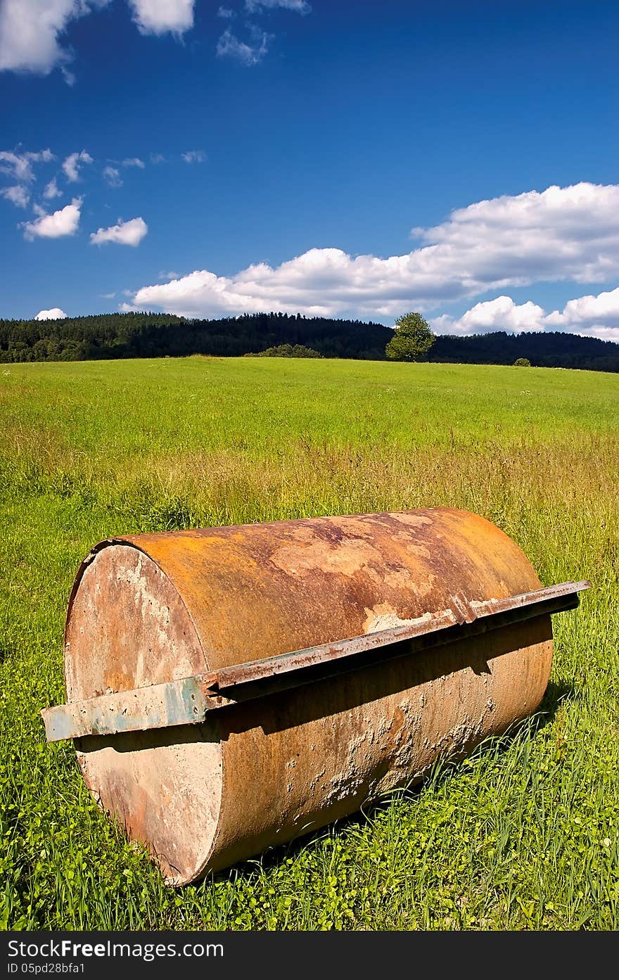 Agricultural machine on the field with trees in the background. Agricultural machine on the field with trees in the background