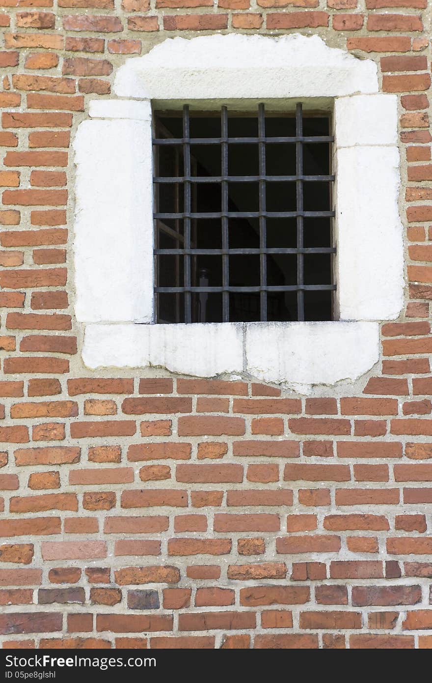 Old window with metal bars in the wall of church , Krakow,Poland.