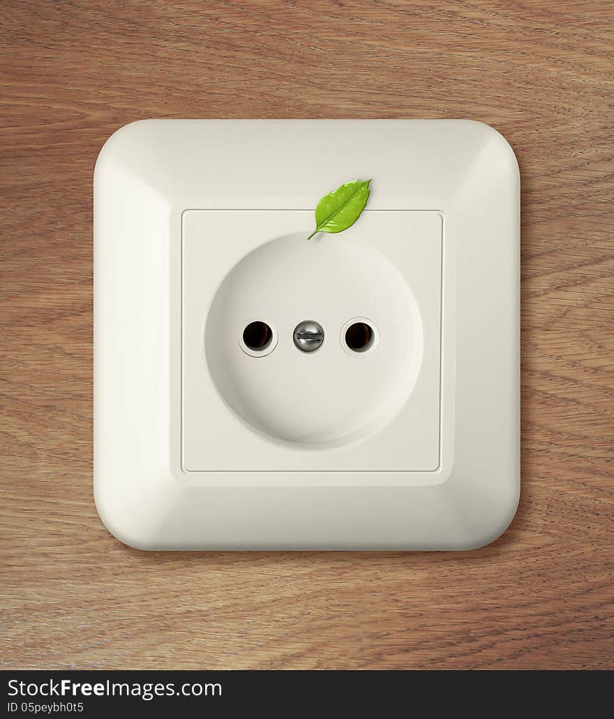 Outlet on wooden wall with leaf. go green power concept.